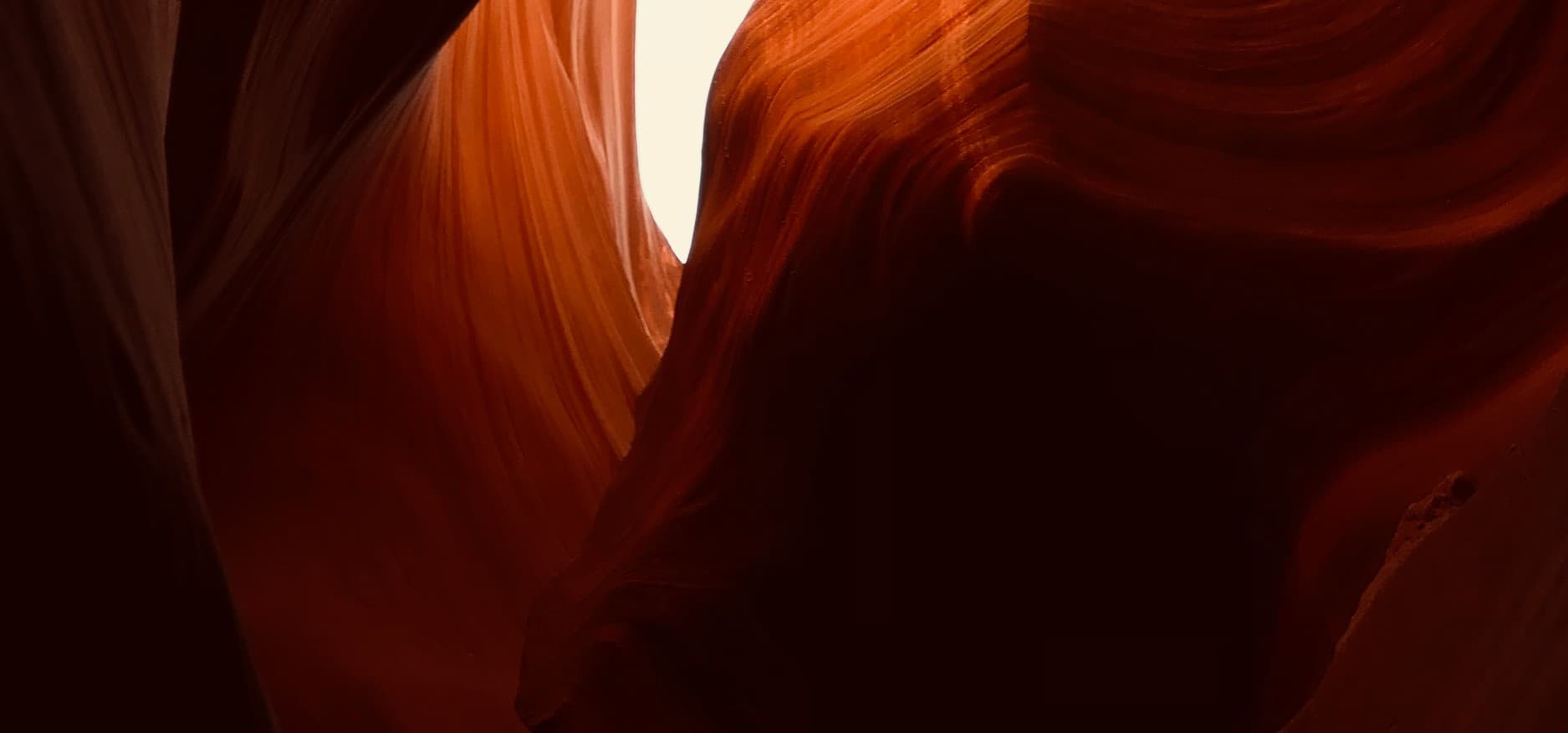 Textura de roca tallada por agua y viento, tonos rojos y naranjas